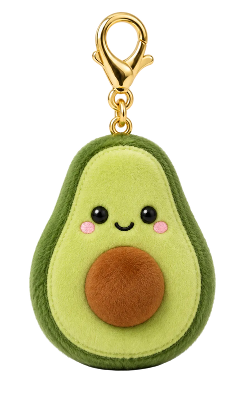 A plush avocado keychain charm with a green outer skin, light green inner flesh, a brown pit, and a cute embroidered face, attached to a gold lobster clasp on a white background.