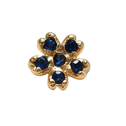 Gold flower-shaped charm with blue gemstones on a white background