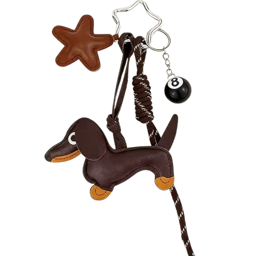 A brown leather keychain featuring a dachshund charm, a star-shaped piece, and an 8-ball bead on a silver keyring, shown against a plain white background.