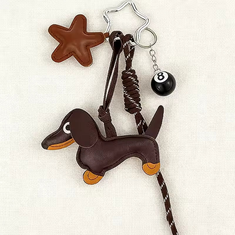Dog-shaped keychain with star, leash, and ball on a white background