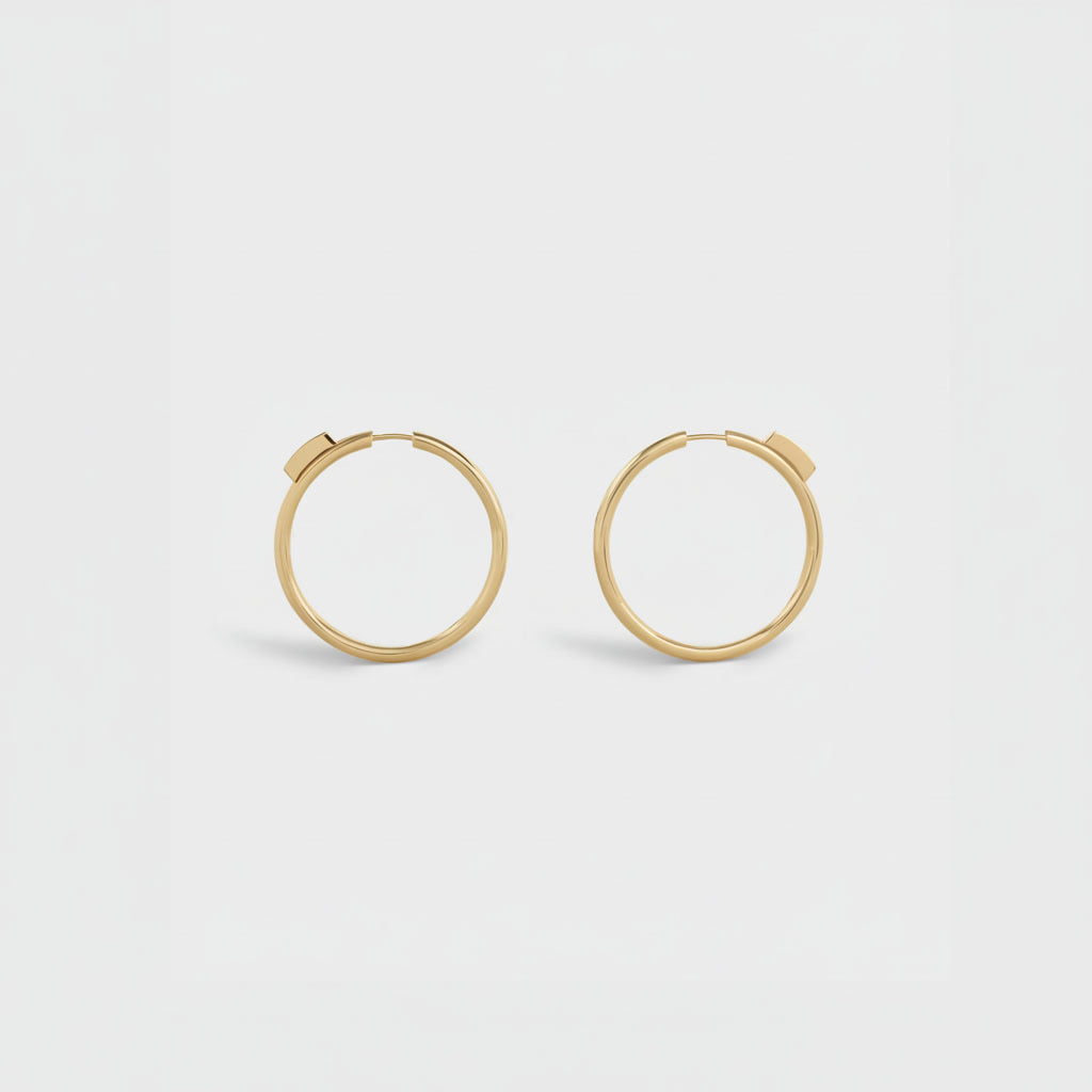 Gold hoop earrings on a light gray background