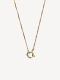 Gold necklace with a small round pendant on a light gray background