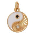 Gold and white yin yang pendant with black and diamond accents on a beige background