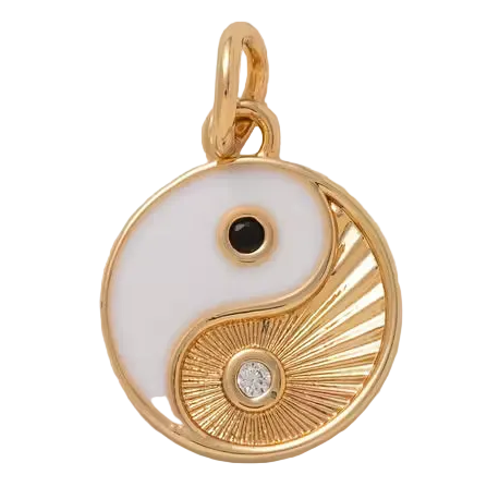 Gold and white yin yang pendant with black and diamond accents on a beige background